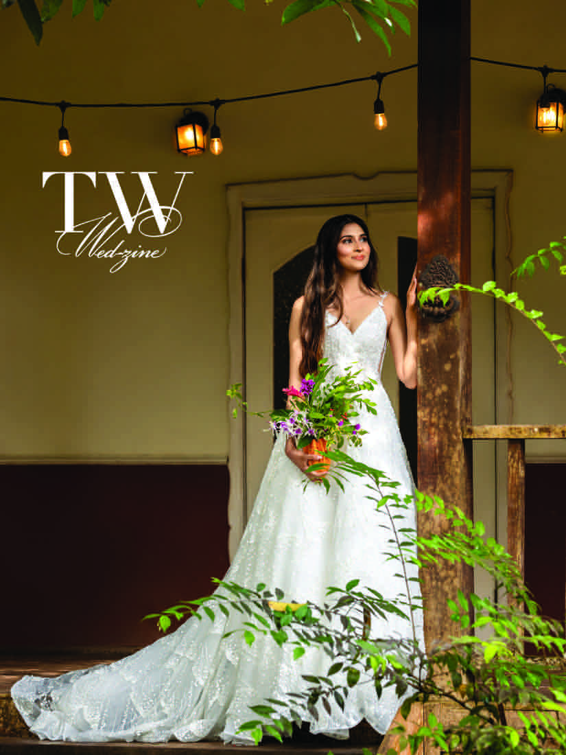 TW Wed-Zine 2026 cover: a bride in a lace gown holding a bouquet on a lantern-lit veranda